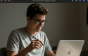 Um homem pesquisando em seu notebook alguns brindes sustentáveis